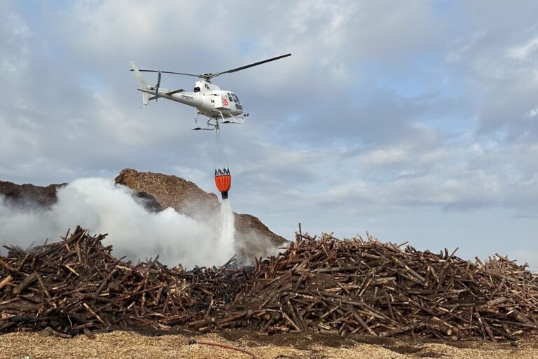 Helicopter water bomber helps douse flames at GreenFirst Forest Products in Cochrane